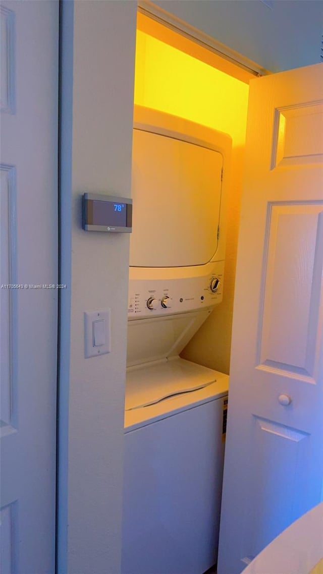 clothes washing area featuring stacked washer / dryer