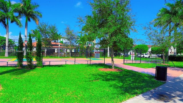 view of community with basketball court and a lawn