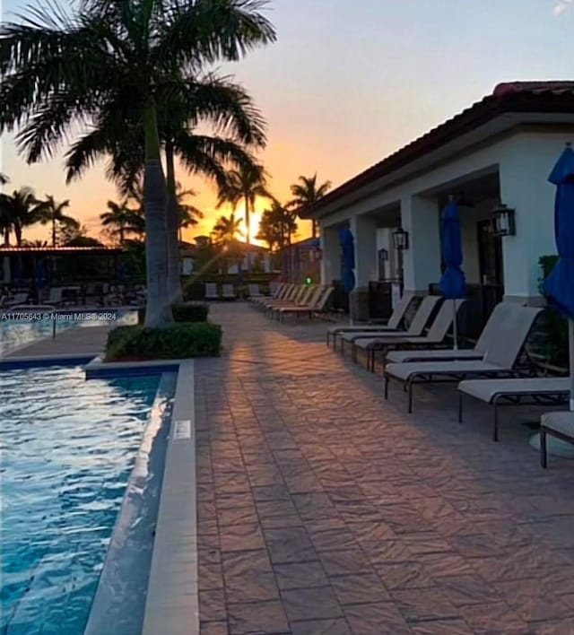 pool at dusk with a patio