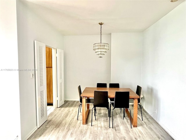 dining space featuring an inviting chandelier and light wood-type flooring