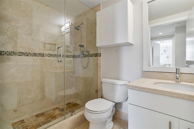 bathroom featuring vanity, toilet, and a shower with shower door