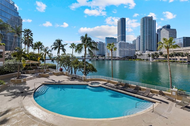 view of swimming pool featuring a water view and a patio area