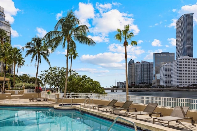 view of pool featuring a patio and a water view