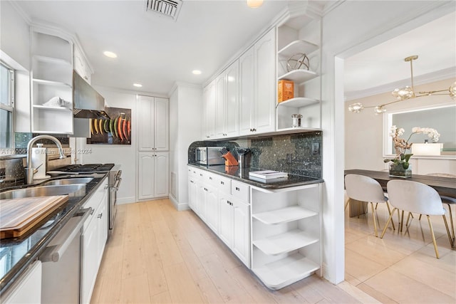 kitchen featuring decorative backsplash, light hardwood / wood-style floors, and white cabinetry