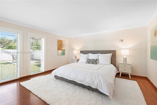 bedroom featuring hardwood / wood-style flooring, crown molding, and access to outside