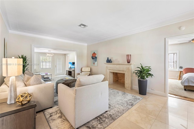 living room with a high end fireplace, a wealth of natural light, crown molding, and ceiling fan