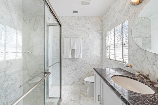 bathroom with vanity, toilet, tile walls, and walk in shower