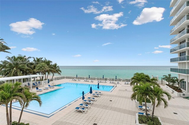 view of pool featuring a patio and a water view