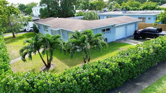 view of front of property with a garage and a front lawn