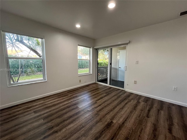 unfurnished room with dark hardwood / wood-style floors and plenty of natural light