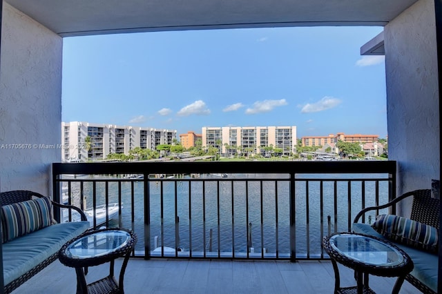 balcony featuring outdoor lounge area and a water view