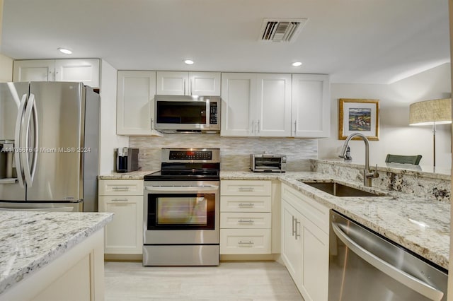 2687 N Ocean Blvd Unit 402-G, Boca Raton, FL 33431 - kitchen featuring appliances with stainless steel finishes, a sink, light stone counters, white cabinets, and recessed lighting