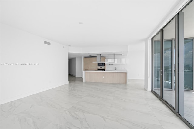 unfurnished living room featuring a wall of windows