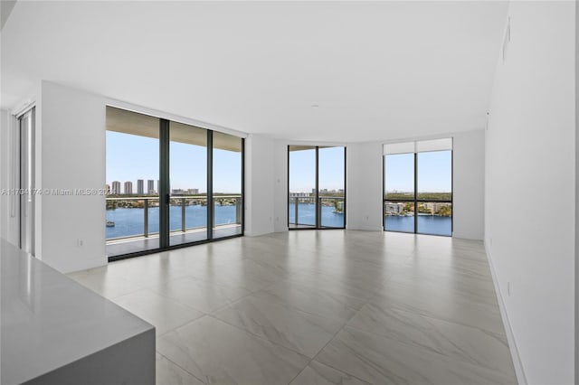 empty room featuring floor to ceiling windows and a water view