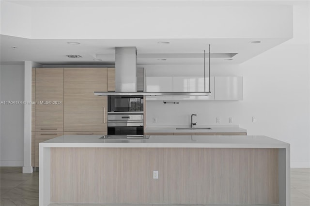 kitchen featuring light brown cabinets, oven, sink, island range hood, and white cabinetry