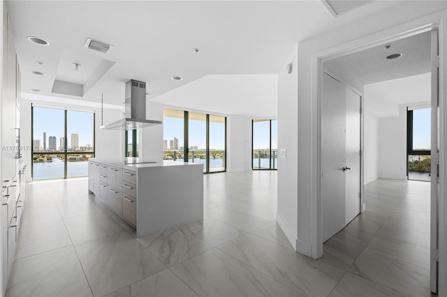 kitchen with white cabinetry, stovetop, a kitchen island, and extractor fan