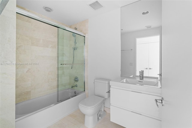 full bathroom featuring shower / bath combination with glass door, vanity, toilet, and tile patterned flooring