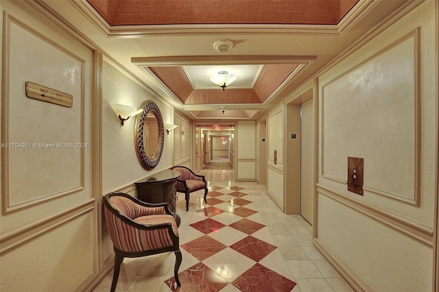 hall featuring a raised ceiling, crown molding, and light tile patterned floors