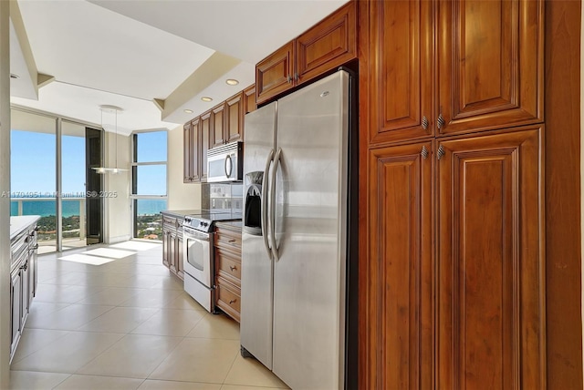 20281 E Country Club Dr Unit 2104, Aventura, FL 33180 - kitchen featuring appliances with stainless steel finishes, baseboards, light tile patterned flooring, dark stone countertops, and brown cabinetry