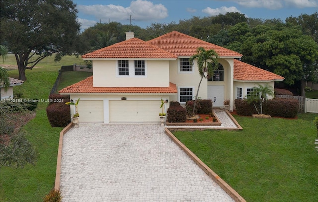 mediterranean / spanish-style house with fence, decorative driveway, stucco siding, a front lawn, and a chimney