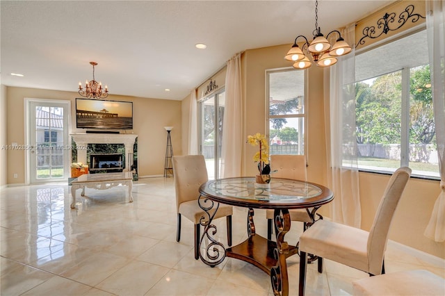 dining area featuring a chandelier, recessed lighting, a fireplace, and baseboards