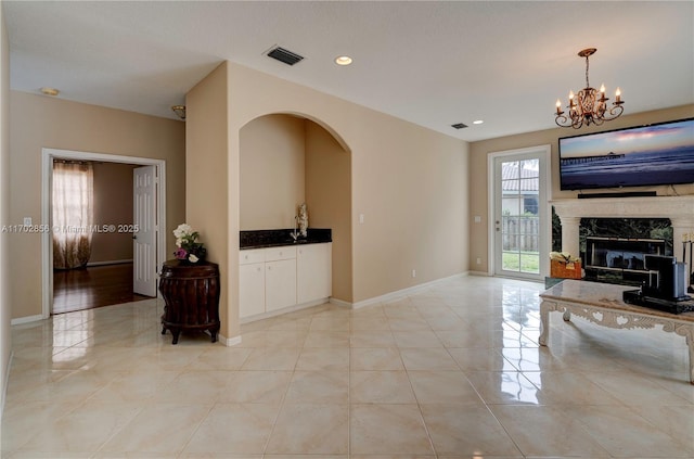 living area with light tile patterned floors, baseboards, visible vents, a high end fireplace, and recessed lighting