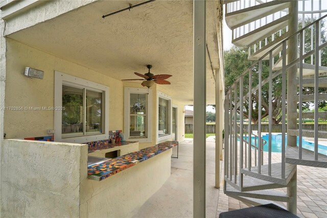 view of patio / terrace featuring a fenced in pool, ceiling fan, and fence