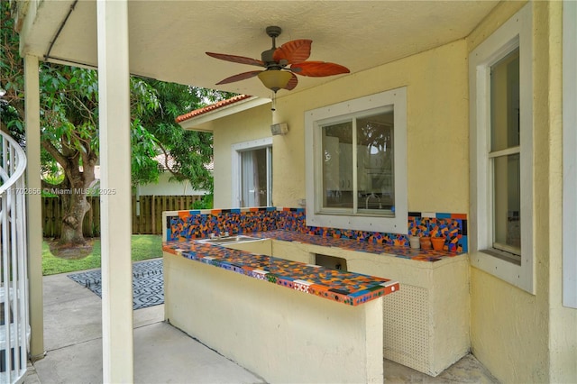 view of patio / terrace featuring fence and a ceiling fan