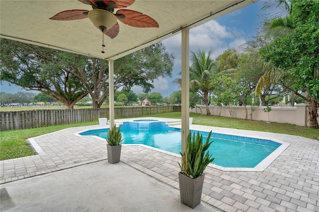 view of pool featuring a patio area, a fenced backyard, a pool with connected hot tub, and ceiling fan