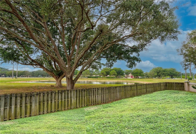 view of yard featuring a water view and fence