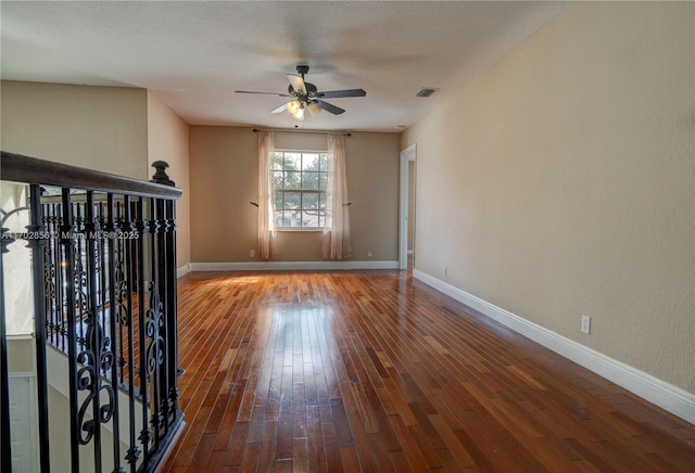 unfurnished living room featuring ceiling fan, a textured ceiling, wood finished floors, visible vents, and baseboards