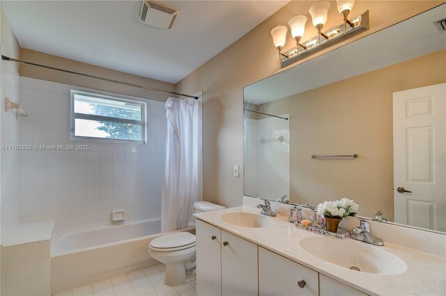 bathroom with toilet, double vanity, a sink, and visible vents