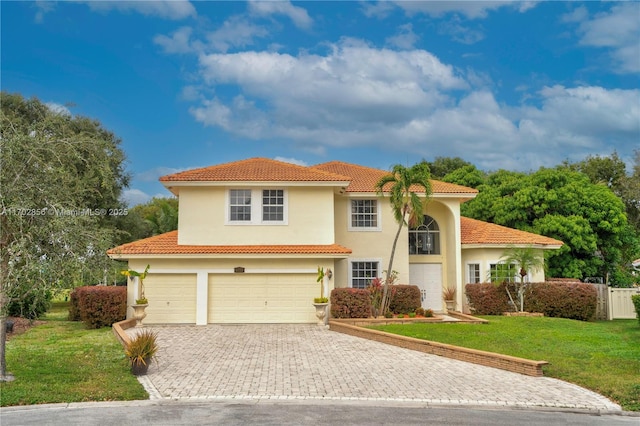 mediterranean / spanish house with a garage, a tiled roof, decorative driveway, stucco siding, and a front lawn