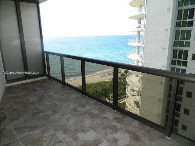 balcony with a water view and a beach view