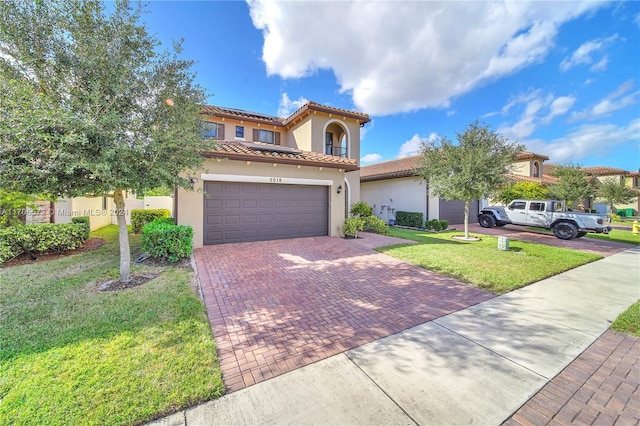 mediterranean / spanish house featuring a front yard and a garage