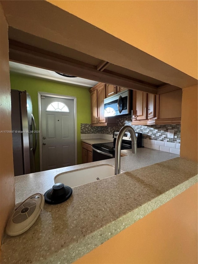 kitchen featuring stainless steel appliances and tasteful backsplash