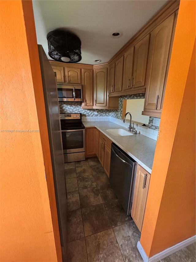 kitchen featuring decorative backsplash, stainless steel appliances, and sink