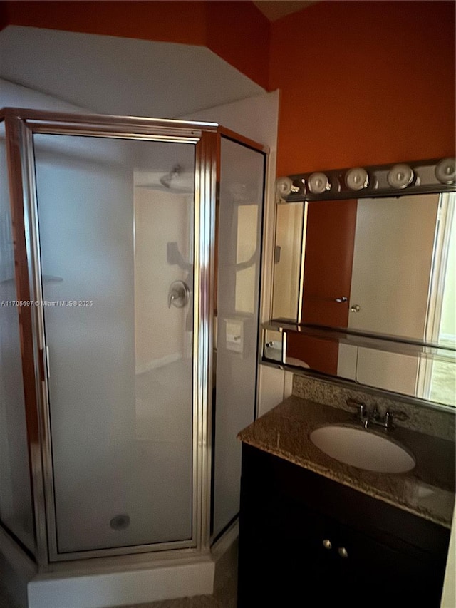 bathroom featuring vanity and a shower with door