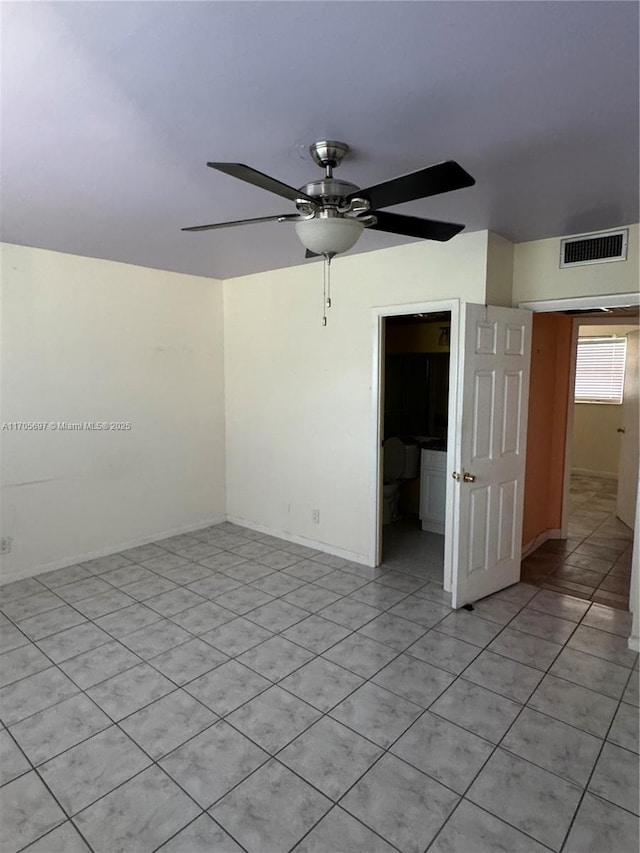 empty room with ceiling fan and light tile patterned floors