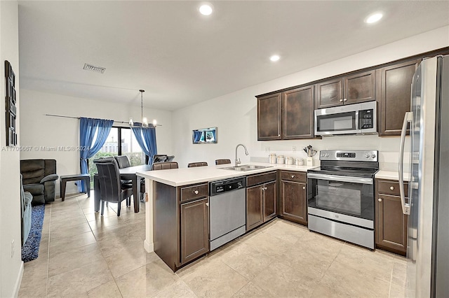 kitchen with sink, stainless steel appliances, an inviting chandelier, kitchen peninsula, and pendant lighting