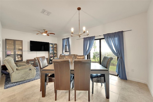 tiled dining room featuring ceiling fan with notable chandelier