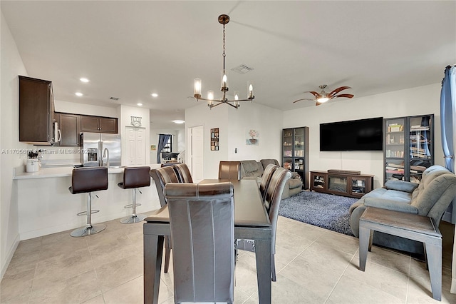 tiled dining space with ceiling fan with notable chandelier