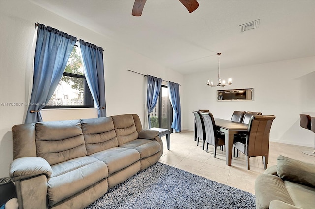 tiled living room with ceiling fan with notable chandelier