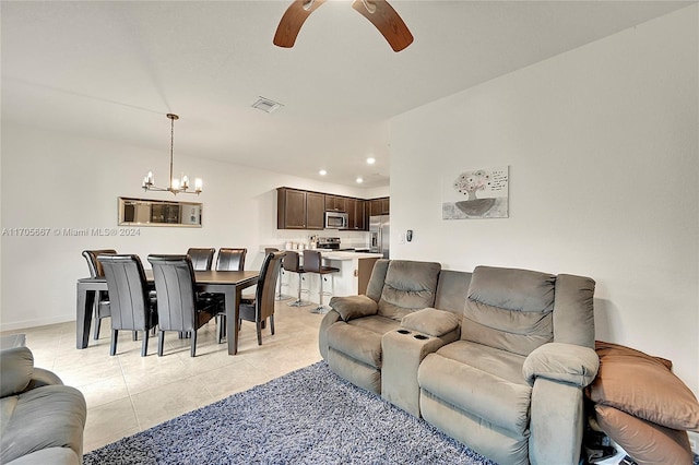 tiled living room featuring ceiling fan with notable chandelier