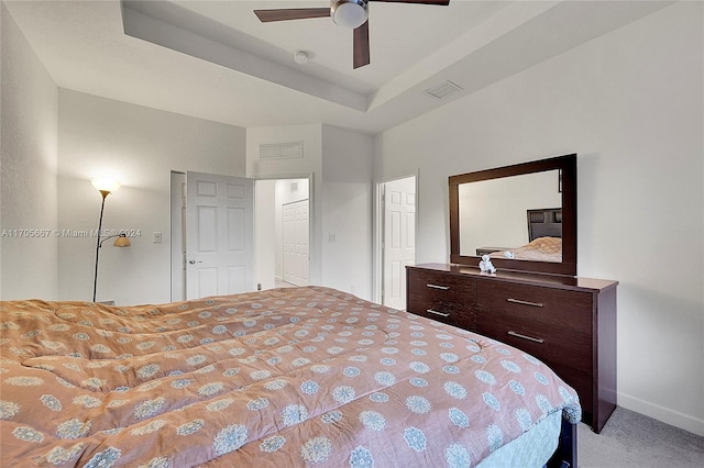 bedroom featuring a tray ceiling, ceiling fan, and light colored carpet