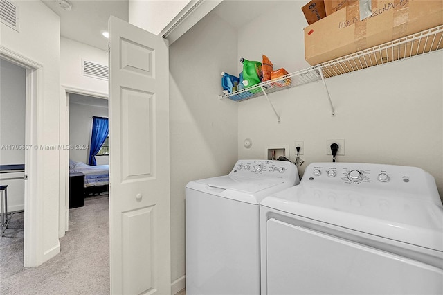 washroom with washer and clothes dryer and light carpet