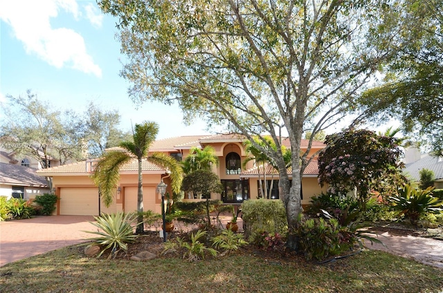 12040 N Eagle Trace Blvd N, Coral Springs, FL 33071 - mediterranean / spanish-style home featuring decorative driveway, a tiled roof, stucco siding, and an attached garage