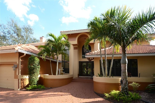 12040 N Eagle Trace Blvd N, Coral Springs, FL 33071 - view of front of house with french doors, stucco siding, a garage, and a tiled roof