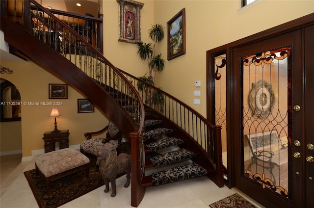 staircase featuring a towering ceiling