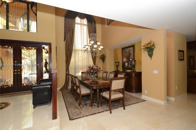 dining space with light tile patterned flooring, french doors, a healthy amount of sunlight, and a notable chandelier